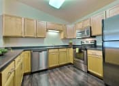 Thumbnail 12 of 18 - a kitchen with stainless steel appliances and wooden cabinets. Moorhead, MN Sandy Creek Apartments