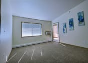 Thumbnail 4 of 18 - a living room with white walls, a window, and a door. Moorhead, MN Sandy Creek Apartments