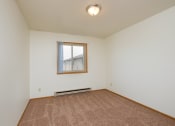 Thumbnail 20 of 22 - an empty living room with carpet and a window. Fargo, ND Sargent Apartments