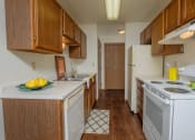 Thumbnail 19 of 22 - a kitchen with white appliances and wooden cabinets. Fargo, ND Sargent Apartments