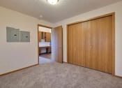 Thumbnail 8 of 23 - a bedroom with a closet and a door to a hallway. Fargo, ND Somerset Apartments