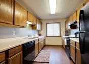 Thumbnail 5 of 23 - a kitchen with black appliances and white countertops. Fargo, ND Somerset Apartments