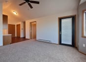 Thumbnail 6 of 23 - a living room with a patio door and office space in the background. Fargo, ND Somerset Apartments