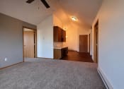 Thumbnail 7 of 23 - a living room with a bedroom and office space in the background. Fargo, ND Somerset Apartments