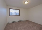 Thumbnail 7 of 19 - a bedroom with a window and a carpeted floor. Fargo, ND South Pointe Apartments