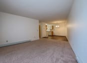 Thumbnail 5 of 19 - a living room with a kitchen and dining room in the background. Fargo, ND South Pointe Apartments