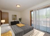Thumbnail 3 of 19 - a bedroom with a bed and glass sliding door to a patio. Fargo, ND South Pointe Apartments