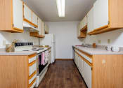 Thumbnail 15 of 19 - a kitchen with white appliances and wooden cabinets. Fargo, ND South Pointe Apartments