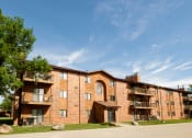Thumbnail 25 of 25 - a brick apartment building with balconies and a blue sky. Fargo, ND Southview Village Apartments
