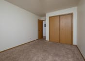 Thumbnail 8 of 10 - a bedroom with a closet and a door to a hallway. Fargo, ND Southwind Apartments