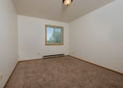 Thumbnail 7 of 10 - a bedroom with carpeted floors and a window. Fargo, ND Southwind Apartments