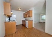 Thumbnail 5 of 10 - a kitchen with white appliances and a living room in the background.Fargo, ND Southwind Apartments