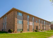 Thumbnail 10 of 10 - a three level apartment building with green grass out front. Fargo, ND Southwind Apartments