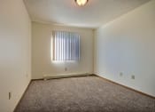 Thumbnail 7 of 10 - a spacious bedroom with carpet and a window. Fargo, ND Sterling Park Apartments