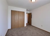 Thumbnail 6 of 10 - a bedroom with a closet and a door to a hallway. Fargo, ND Sterling Park Apartments