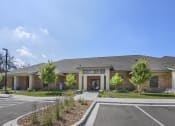Thumbnail 31 of 32 - a large brick building with a parking lot and a driveway