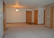 Thumbnail 3 of 5 - an empty living room with three doors and a lamp