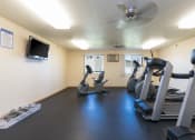 Thumbnail 18 of 20 - a gym with treadmills and other exercise equipment and a tv.Bismarck, ND Sunset Ridge Apartments