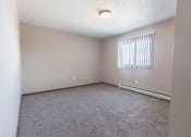 Thumbnail 11 of 27 - Grand Forks, ND Sunview apartments. a bedroom with a large window and beige carpet