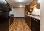 Thumbnail 8 of 27 - Grand Forks, ND Sunview apartments. a kitchen with a black refrigerator freezer next to a black stove top oven