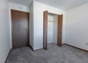 Thumbnail 17 of 27 - Grand Forks, ND Sunview apartments. an empty bedroom with a closet and a carpeted floor