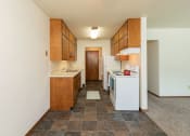 Thumbnail 7 of 34 - a kitchen with white appliances and wooden cabinets. Fargo, ND Islander Apartments
