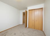 Thumbnail 16 of 28 - a bedroom with a closet and a door to a hallway.Fargo, ND Thunder Creek Apartments