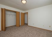 Thumbnail 14 of 16 - an empty room with two doors and a closet. Fargo, ND Twin Parks Apartments.