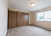 Thumbnail 4 of 6 - Grand Forks, ND Twin Drive Apartments. A bedroom with carpet and a window