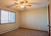 Thumbnail 28 of 45 - an empty bedroom with a ceiling fan and a window. Fargo, ND Urban Plains Apartments