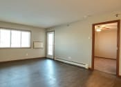 Thumbnail 25 of 45 - an empty living room with wood flooring and a window. Fargo, ND Urban Plains Apartments