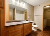 Thumbnail 33 of 45 - a bathroom with a toilet and a sink and a mirror. Fargo, ND Urban Plains Apartments
