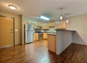Thumbnail 30 of 45 - a kitchen with wood flooring and a stainless steel refrigerator. Fargo, ND Urban Plains Apartments
