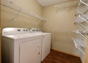 Thumbnail 32 of 45 - a spacious laundry room with a washer and dryer and a closet with shelves. Fargo, ND Urban Plains Apartments