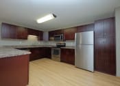 Thumbnail 16 of 45 - a kitchen with wooden cabinets and a stainless steel refrigerator. Fargo, ND Urban Plains Apartments