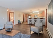 Thumbnail 9 of 45 - a living room with two chairs and a table in front of a kitchen. Fargo, ND Urban Plains Apartments