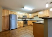 Thumbnail 20 of 45 - a kitchen with wooden cabinets and stainless steel appliances. Fargo, ND Urban Plains Apartments