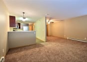 Thumbnail 40 of 45 - the living room and kitchen of an empty apartment with carpeting. Fargo, ND Urban Plains Apartments