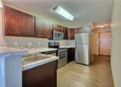 Thumbnail 38 of 45 - a kitchen with stainless steel appliances and wooden cabinets. Fargo, ND Urban Plains Apartments