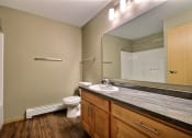 Thumbnail 36 of 45 - a bathroom with sink toilet and mirror. Fargo, ND Urban Plains Apartments