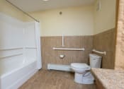 Thumbnail 10 of 21 - a bathroom with a toilet sink and mirror. Fargo, ND Crossroads Apartments