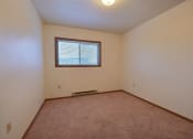 Thumbnail 14 of 26 - the living room of an empty house with a window. Fargo, ND Village West Apartments
