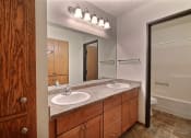 Thumbnail 16 of 26 - a bathroom with two sinks and a large mirror. Fargo, ND Village West Apartments