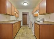 Thumbnail 9 of 26 - a kitchen with wooden cabinets and a white stove and refrigerator. Fargo, ND Village West Apartments