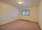Thumbnail 10 of 26 - the living room of an empty house with a window. Fargo, ND Village West Apartments
