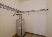 Thumbnail 25 of 26 - a closet with a shelf and a water heater Fargo, ND Village West Apartments