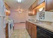 Thumbnail 13 of 26 - a kitchen with white appliances and wooden cabinets. Fargo, ND Village West Apartments