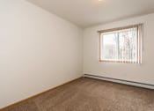 Thumbnail 9 of 10 - Grand Forks, ND Vista Apartments. a bedroom with white walls and a large window