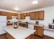 Thumbnail 6 of 10 - Grand Forks, ND Vista Apartments. a kitchen with a large island with a bowl of fruit on it