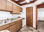 Thumbnail 5 of 8 - Grand Forks, ND Washington Apartments. A kitchen with a stove and a closet